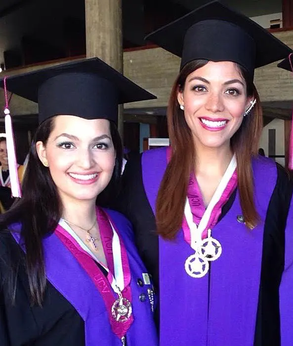 Estudiantes de odontología en graduación con toga y birrete, celebración académica en campus odontológico.