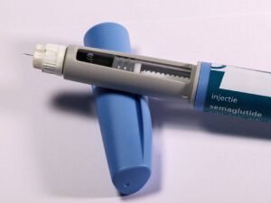 Jeringa dental con aguja y capuchón azul, herramienta clínica usada en procedimientos odontológicos para administración de anestesia o tratamientos.